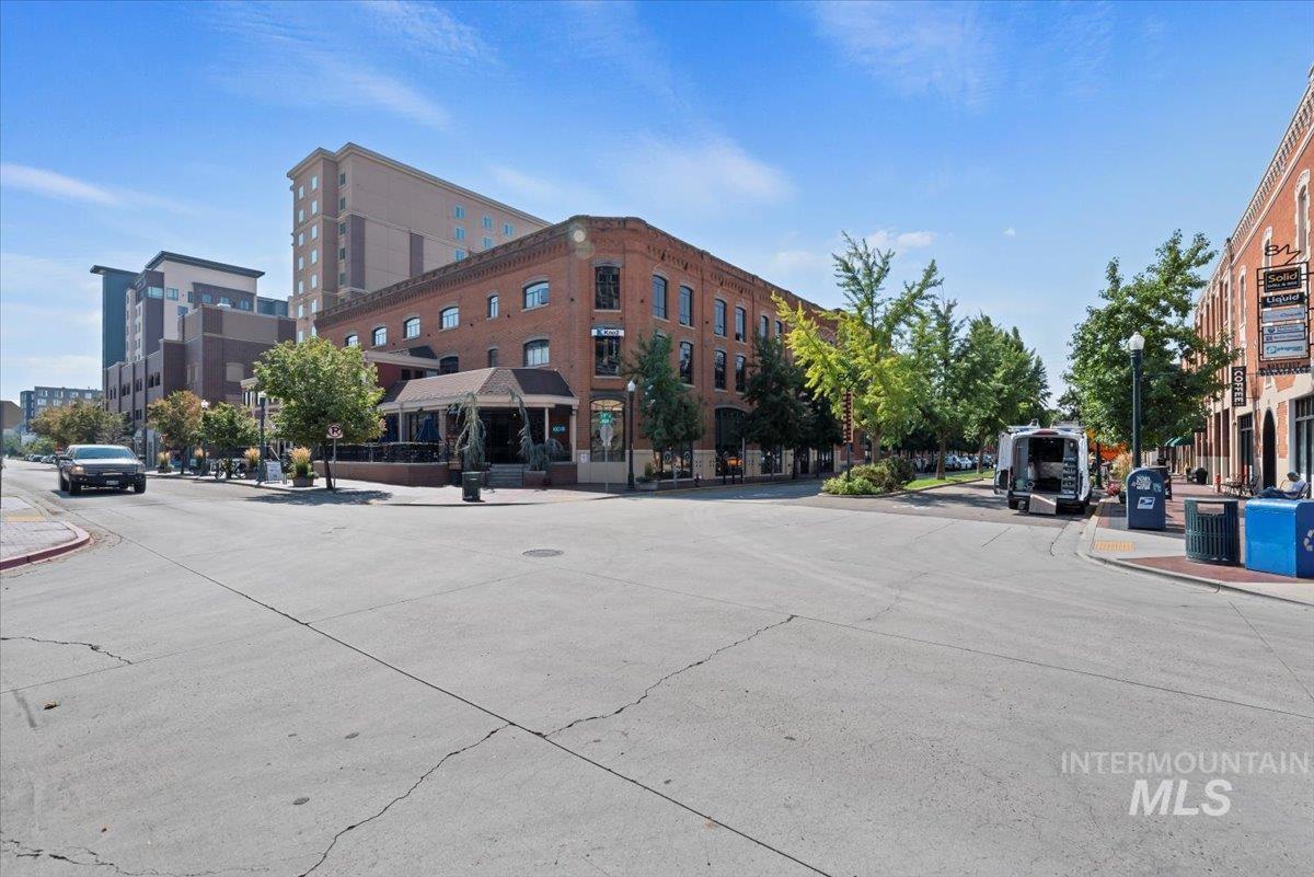 View of concrete road featuring curbs, sidewalks, and street lighting