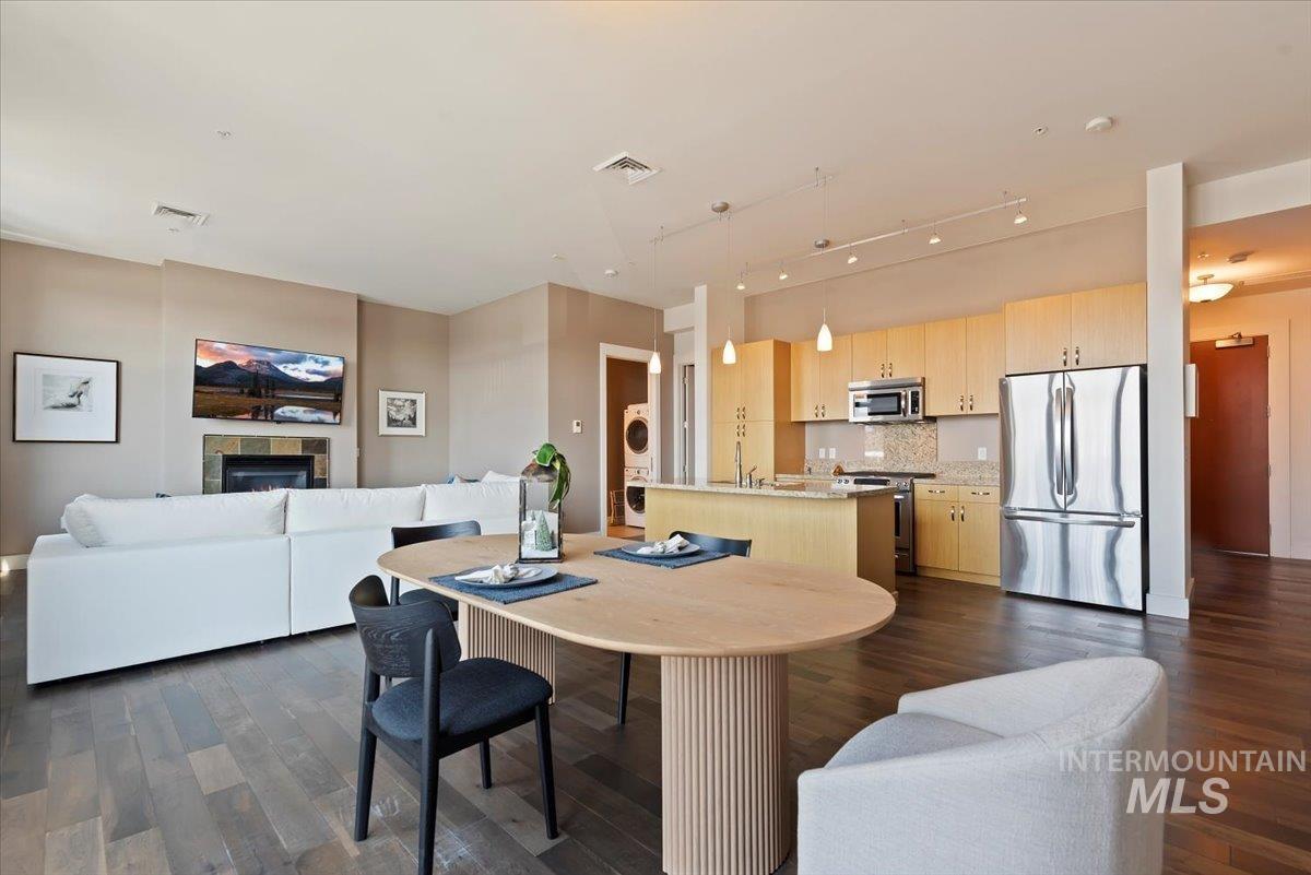 Dining space featuring dark wood finished floors, rail lighting, and a tile fireplace