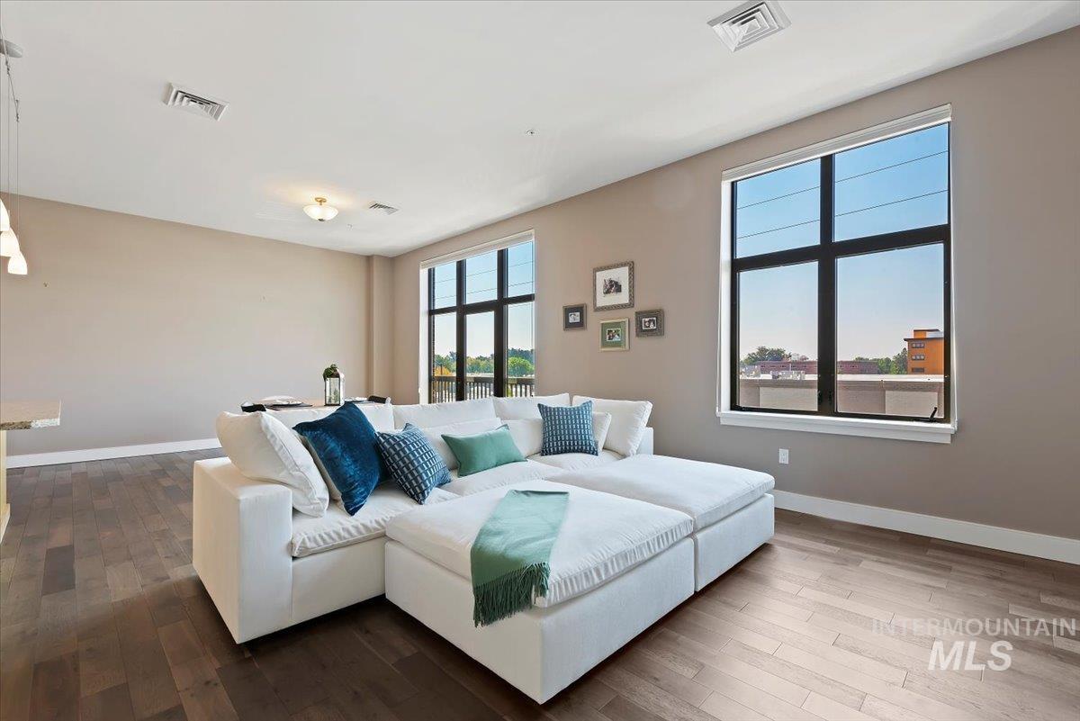 Living area with baseboards and wood-type flooring