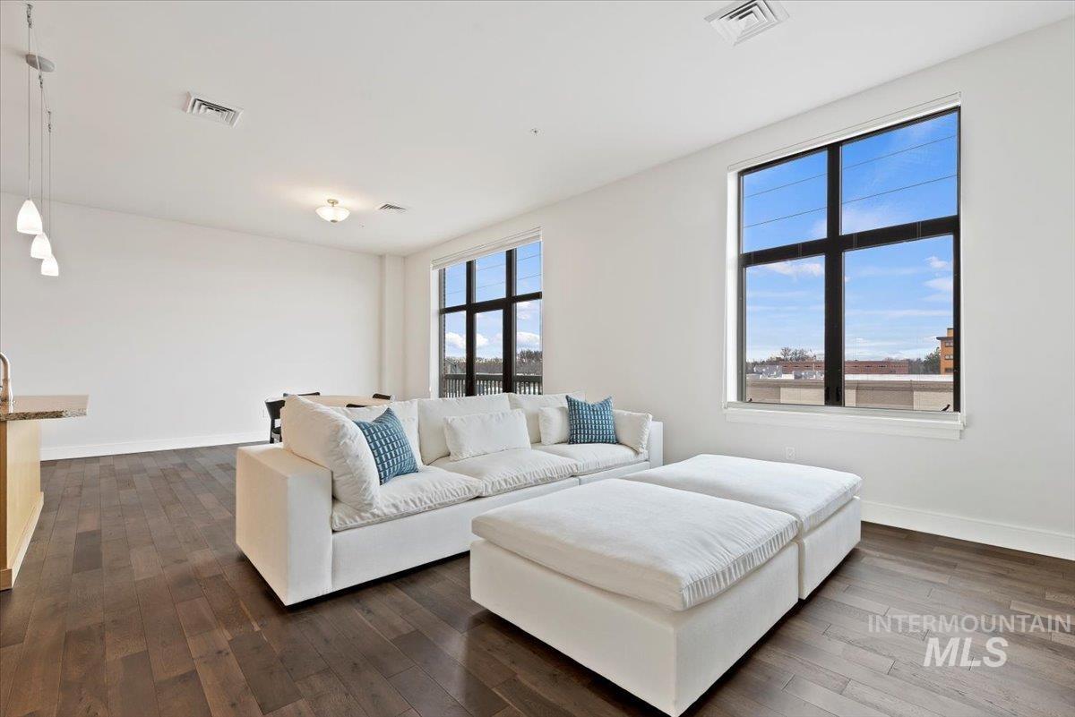 Living area with dark wood-style floors and baseboards
