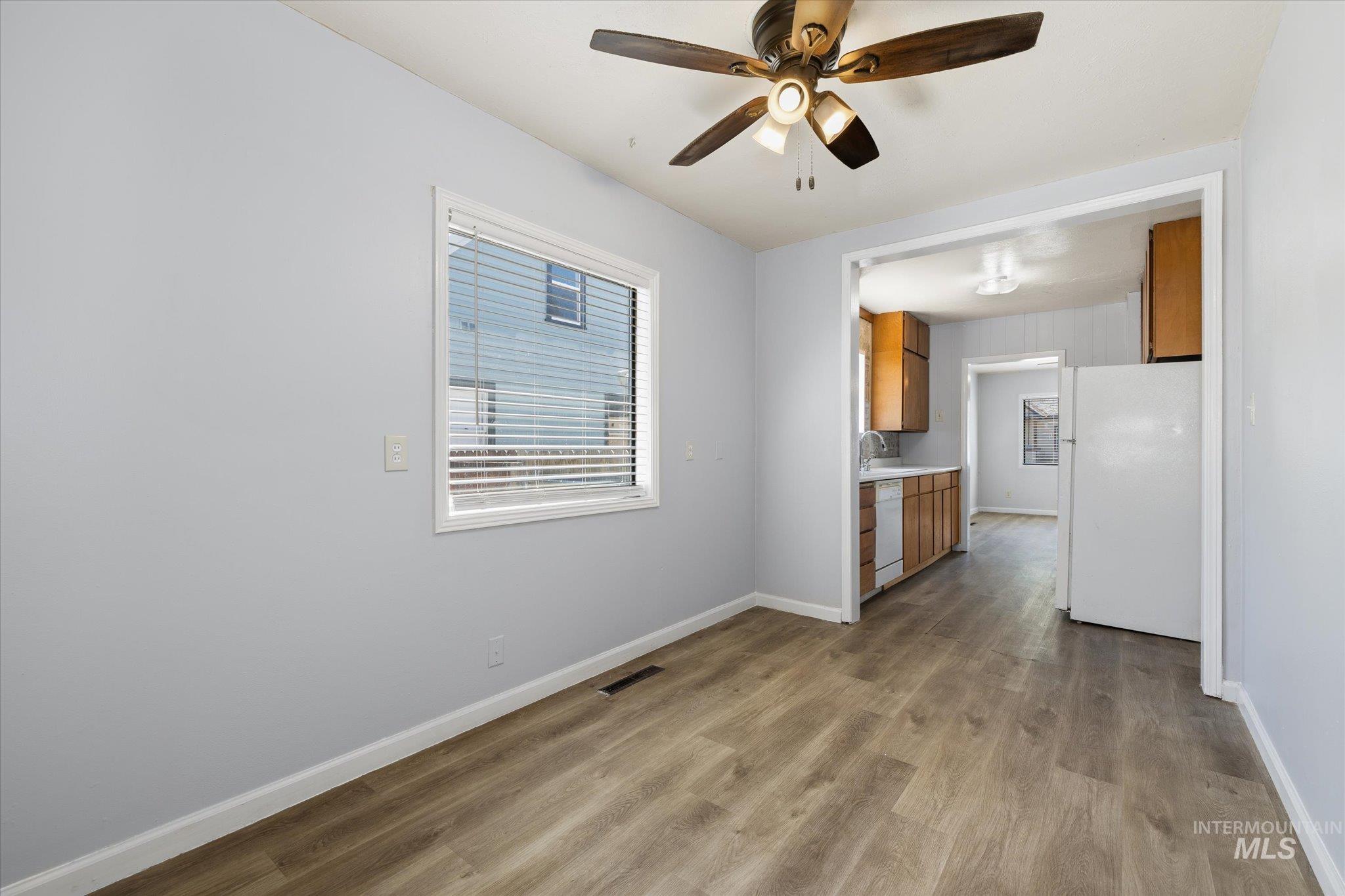 Light-toned wood-finish flooring extends throughout, complemented by light grey walls and white trim