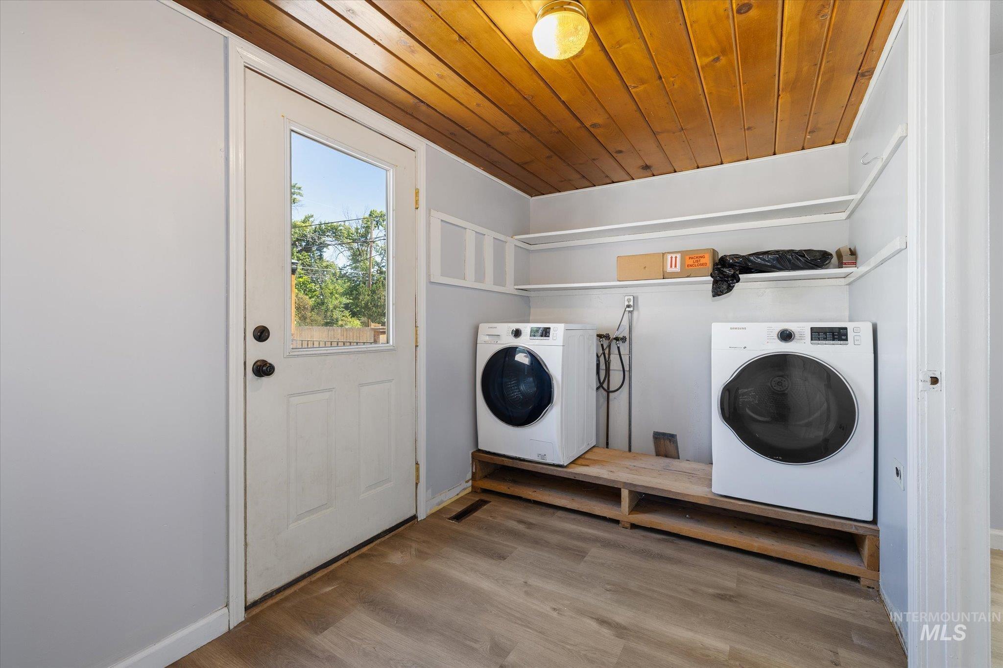 Laundry area featuring wood-finish flooring, a paneled wood ceiling, and built-in shelving