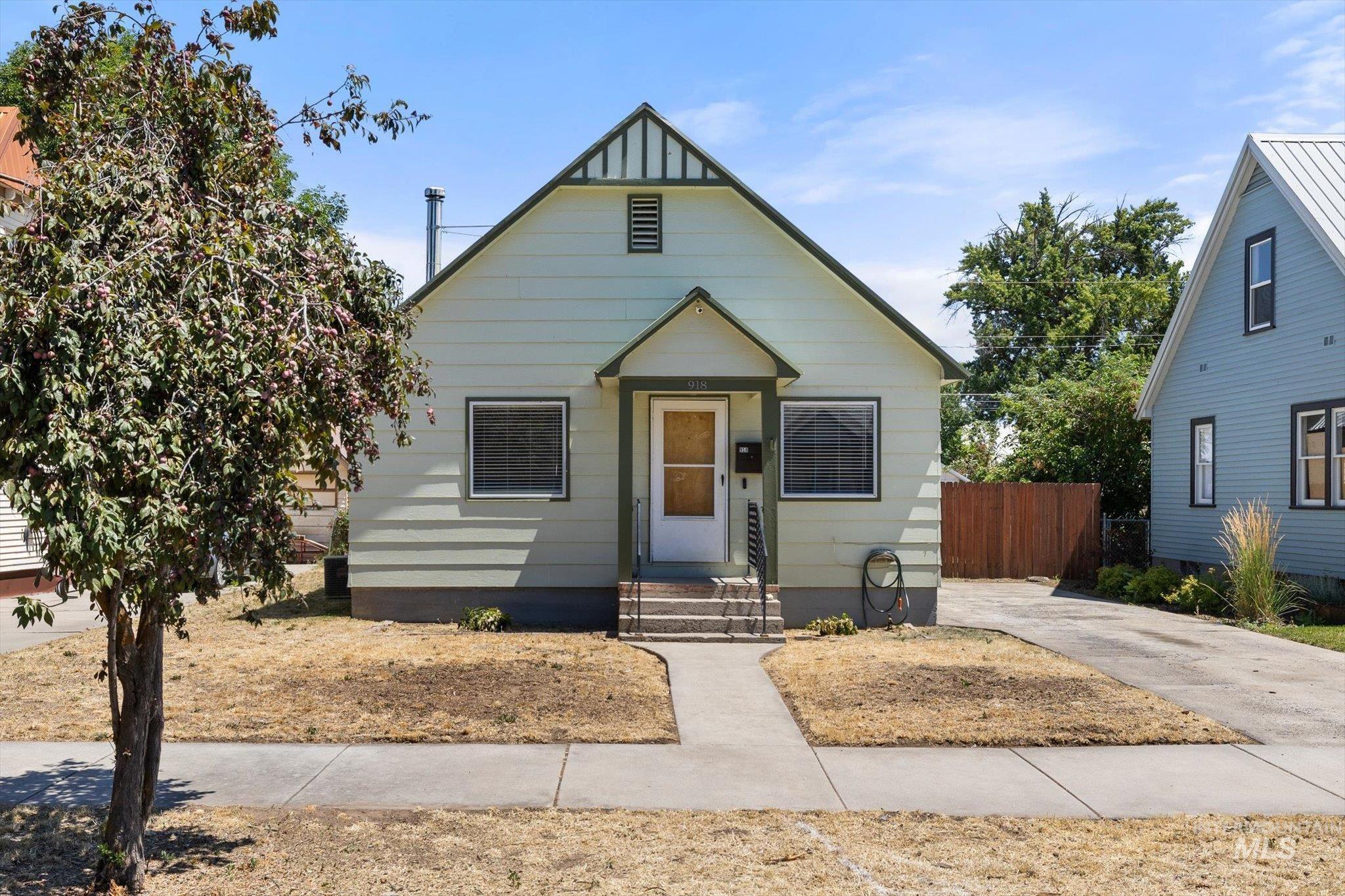 Light green siding exterior with dark green trim and a covered front entry
