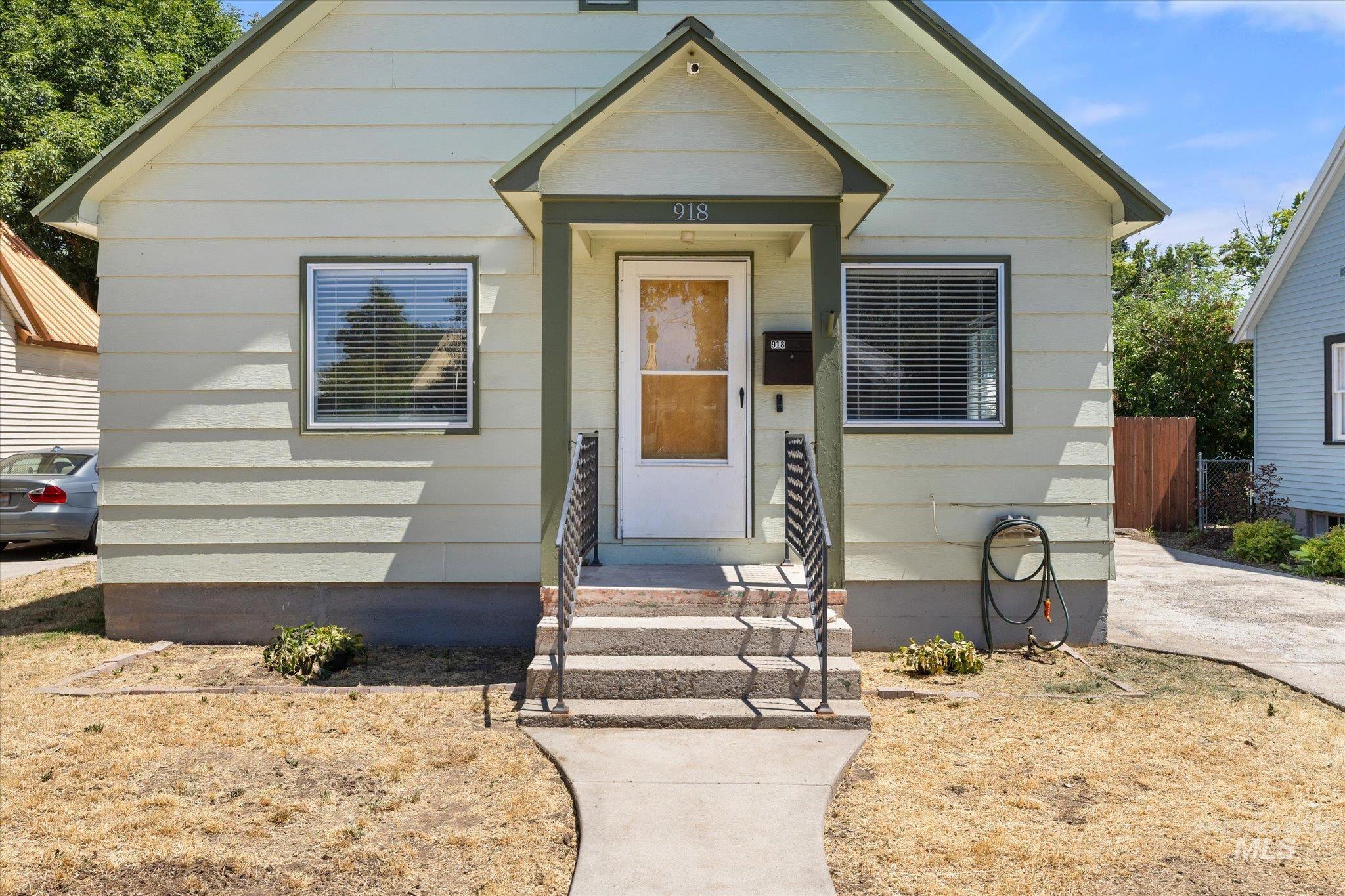 Light green siding exterior with dark green trim and white window frames