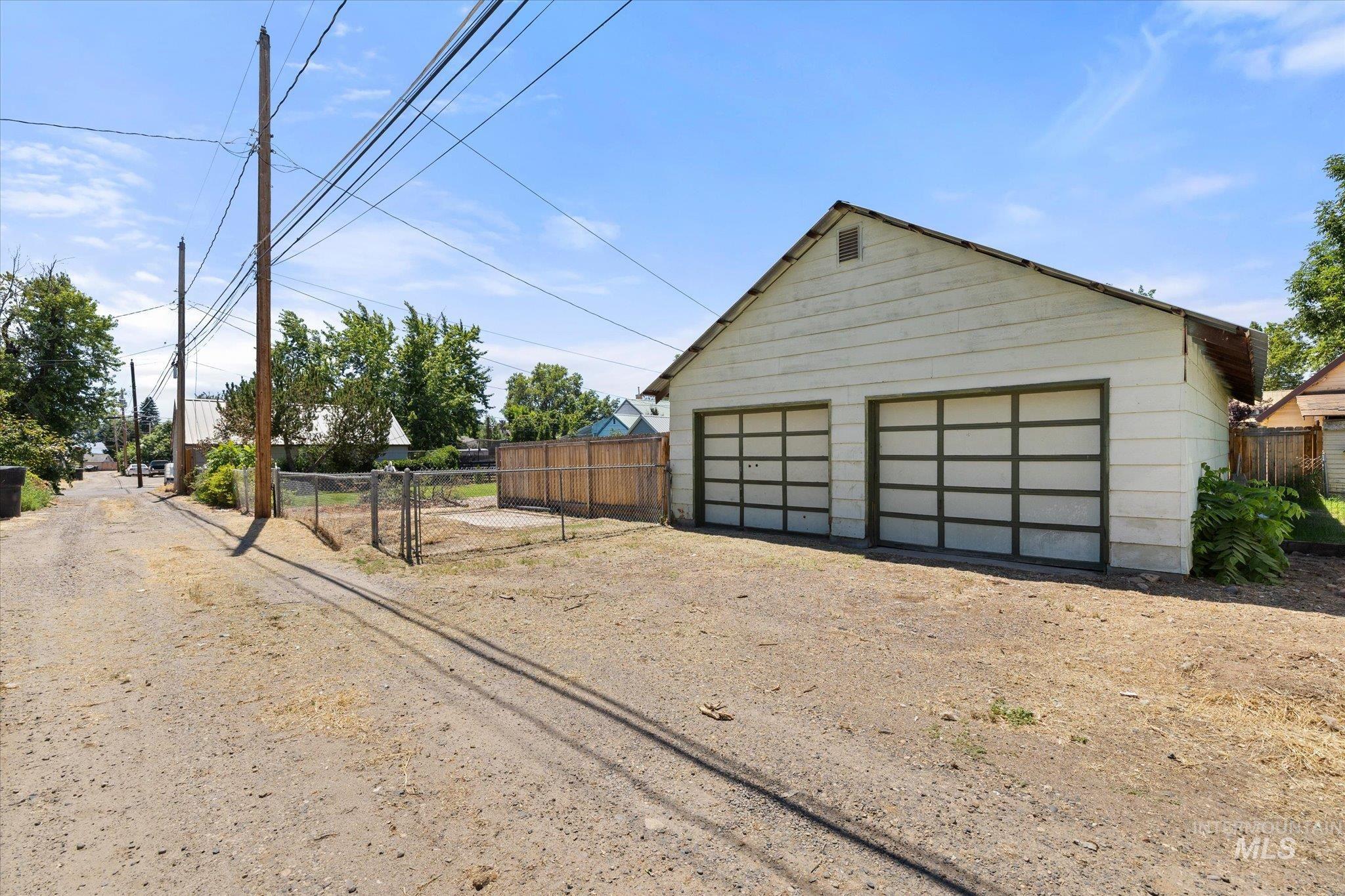Detached two-car garage with horizontal panel siding and two bay doors