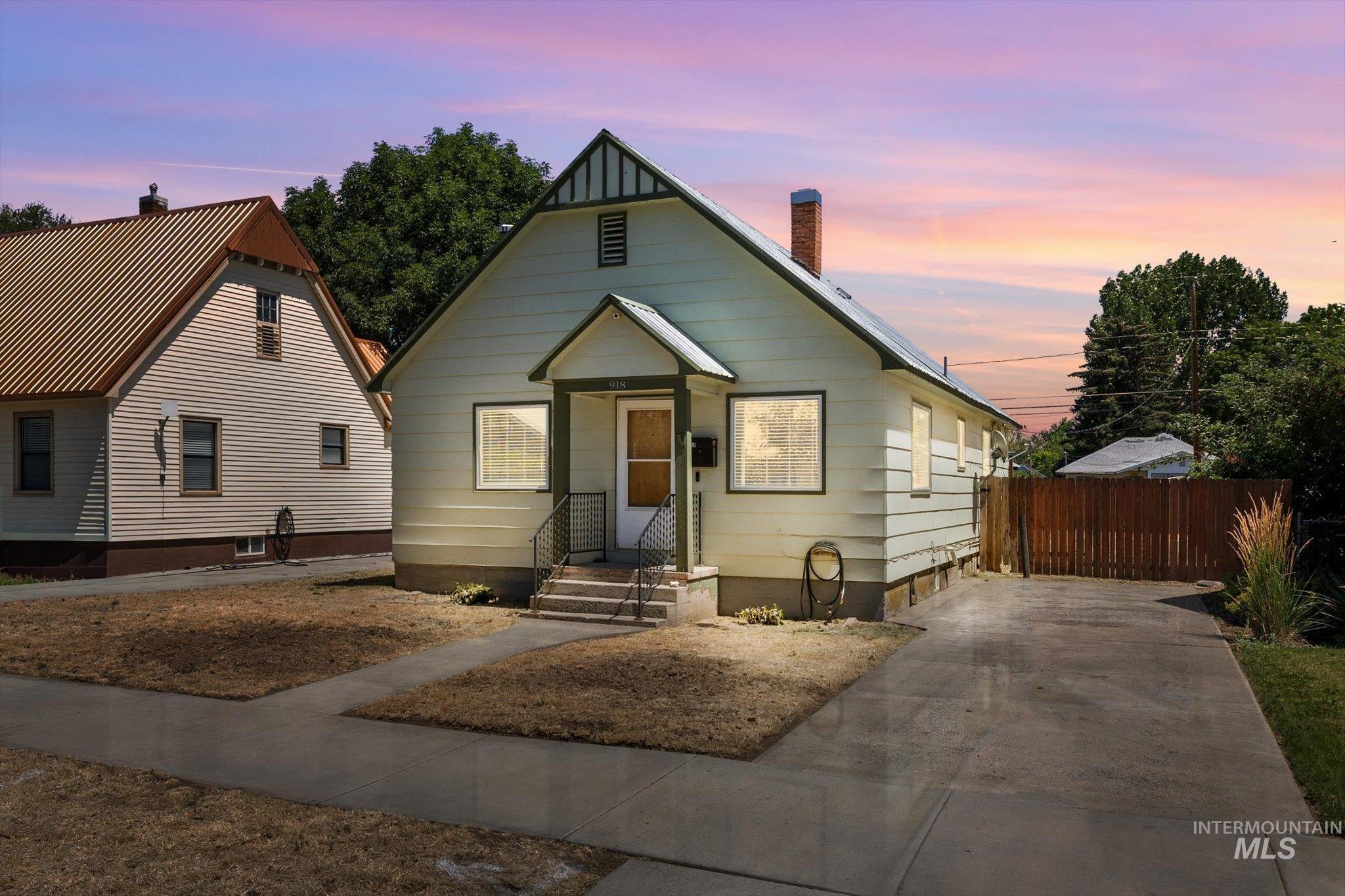 Gable-front home featuring light-colored siding and a covered entry