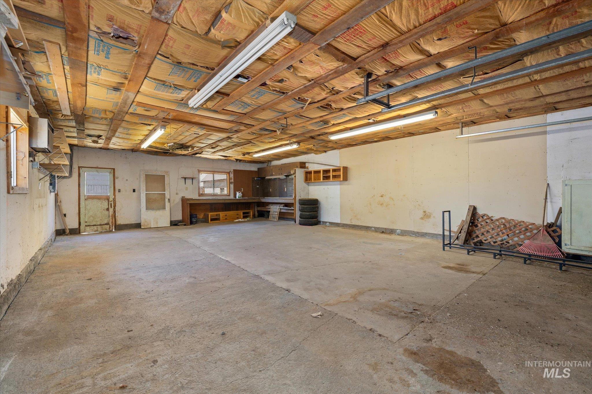 Spacious garage with concrete flooring and exposed beam ceiling