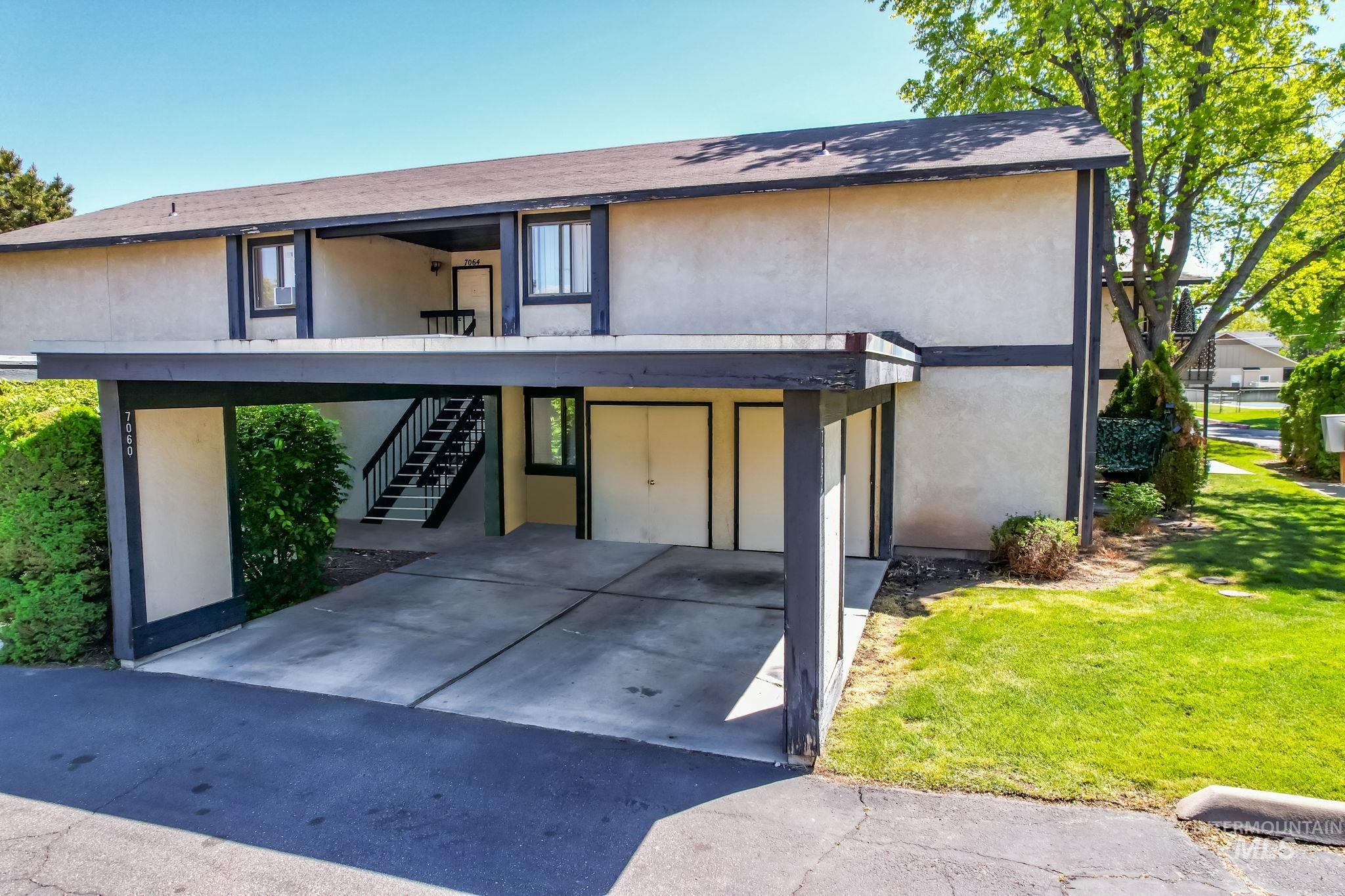View of front of house featuring stairway, stucco siding, a shingled roof, and a balcony