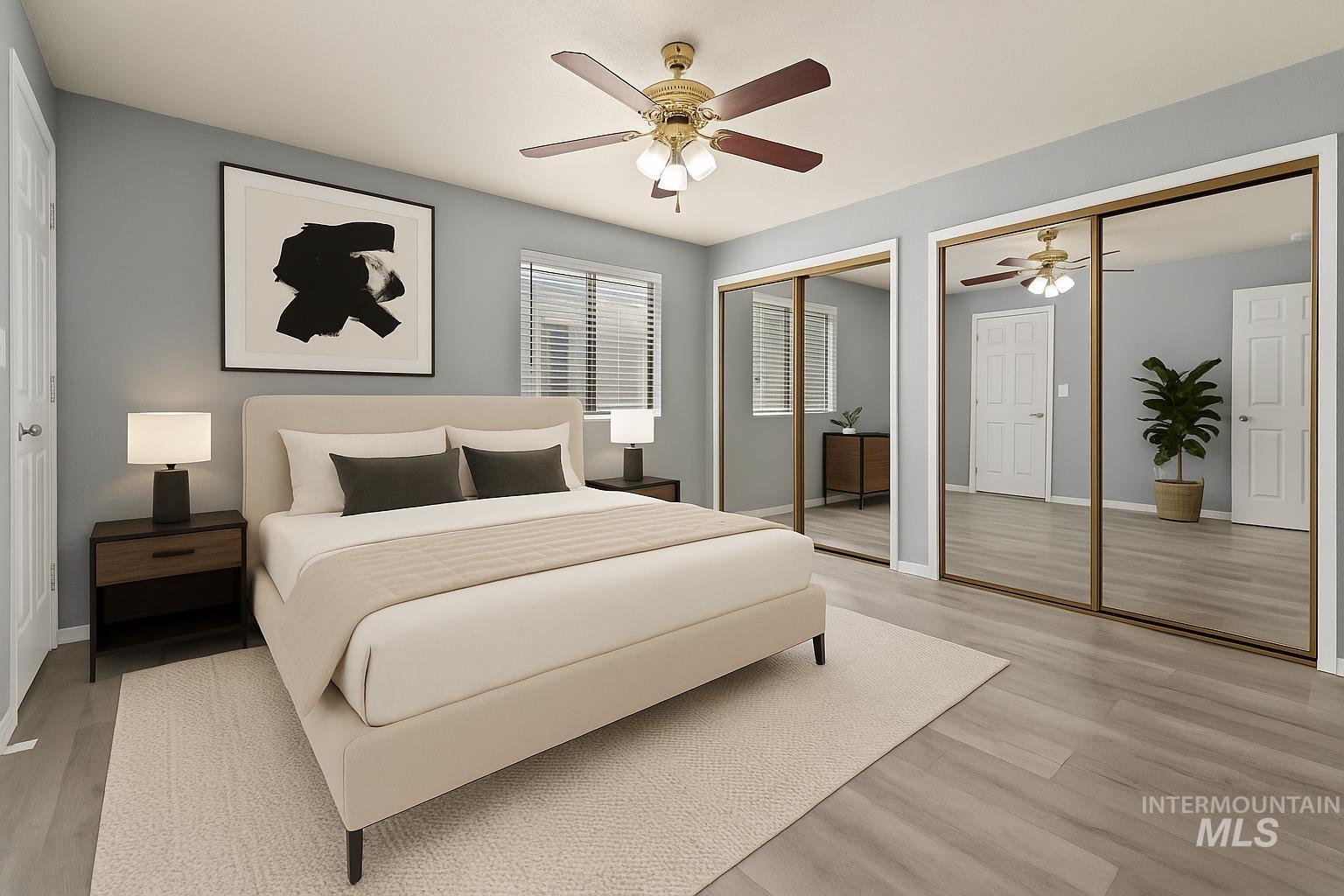 Bedroom with two closets, light wood-type flooring, and a ceiling fan