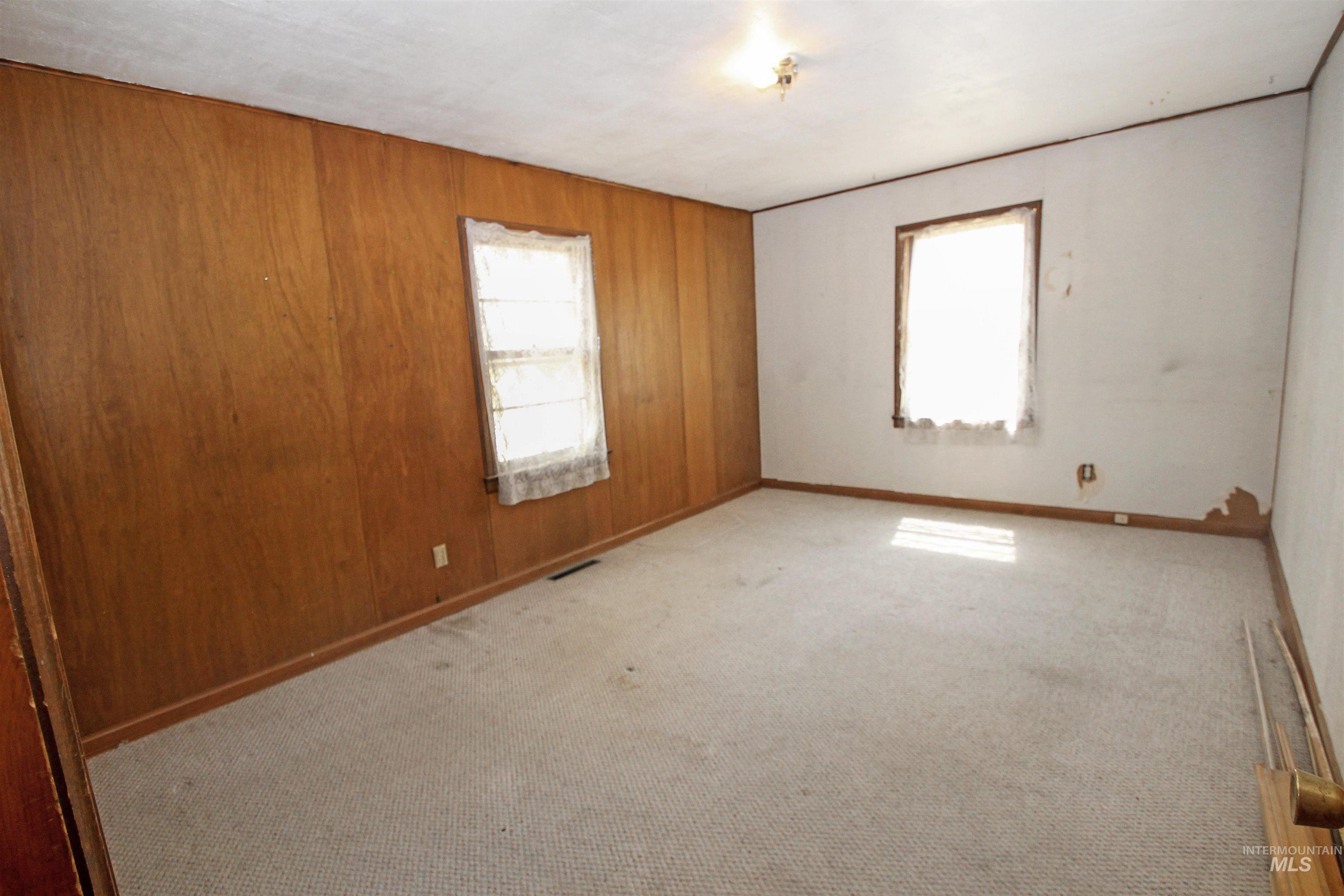Spare room with carpet and wood walls