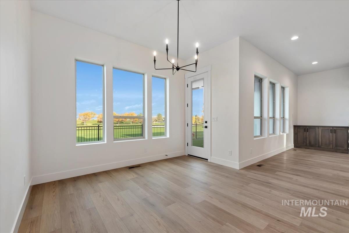 Unfurnished dining area featuring a chandelier, light wood-style floors, and recessed lighting