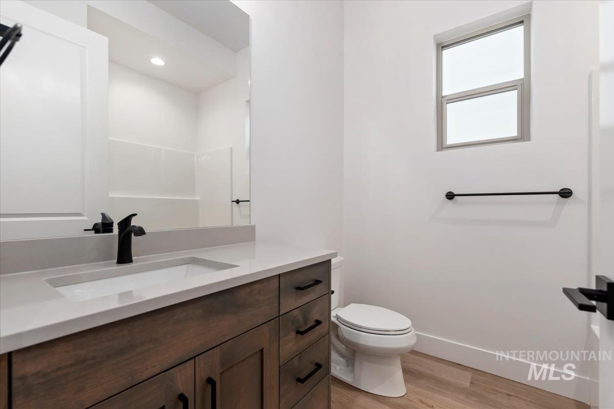 Full bath featuring light wood-type flooring, vanity, and recessed lighting