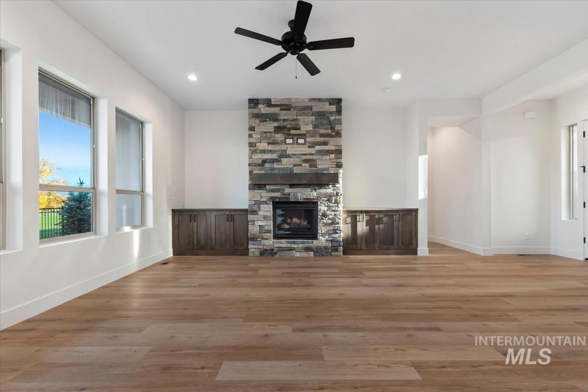 Unfurnished living room featuring healthy amount of natural light, light wood-style floors, a ceiling fan, and recessed lighting