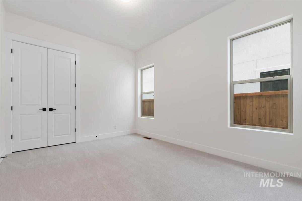 Unfurnished bedroom featuring light colored carpet and a closet