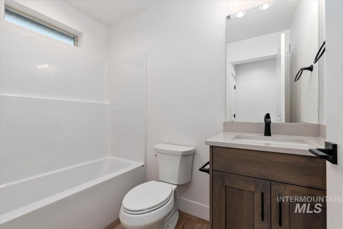 Full bathroom with vanity, bathtub / shower combination, and light wood-style flooring