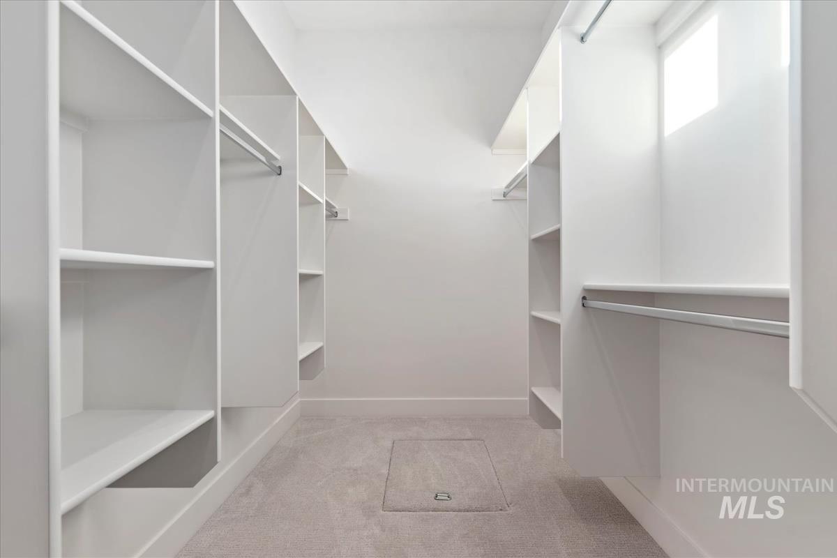 Spacious closet featuring light colored carpet