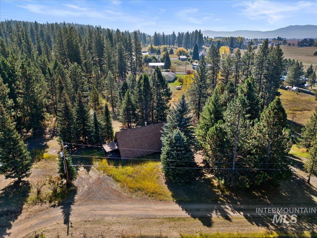 Aerial view of property and surrounding area featuring a mountain backdrop