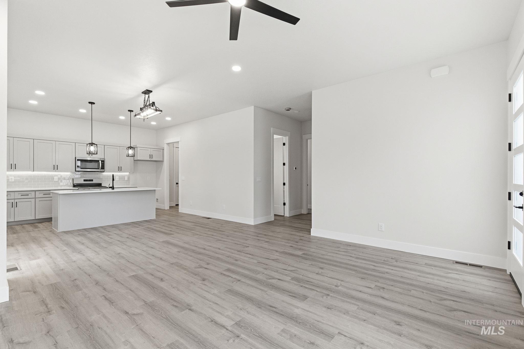 Unfurnished living room featuring recessed lighting, light wood-style flooring, and a ceiling fan