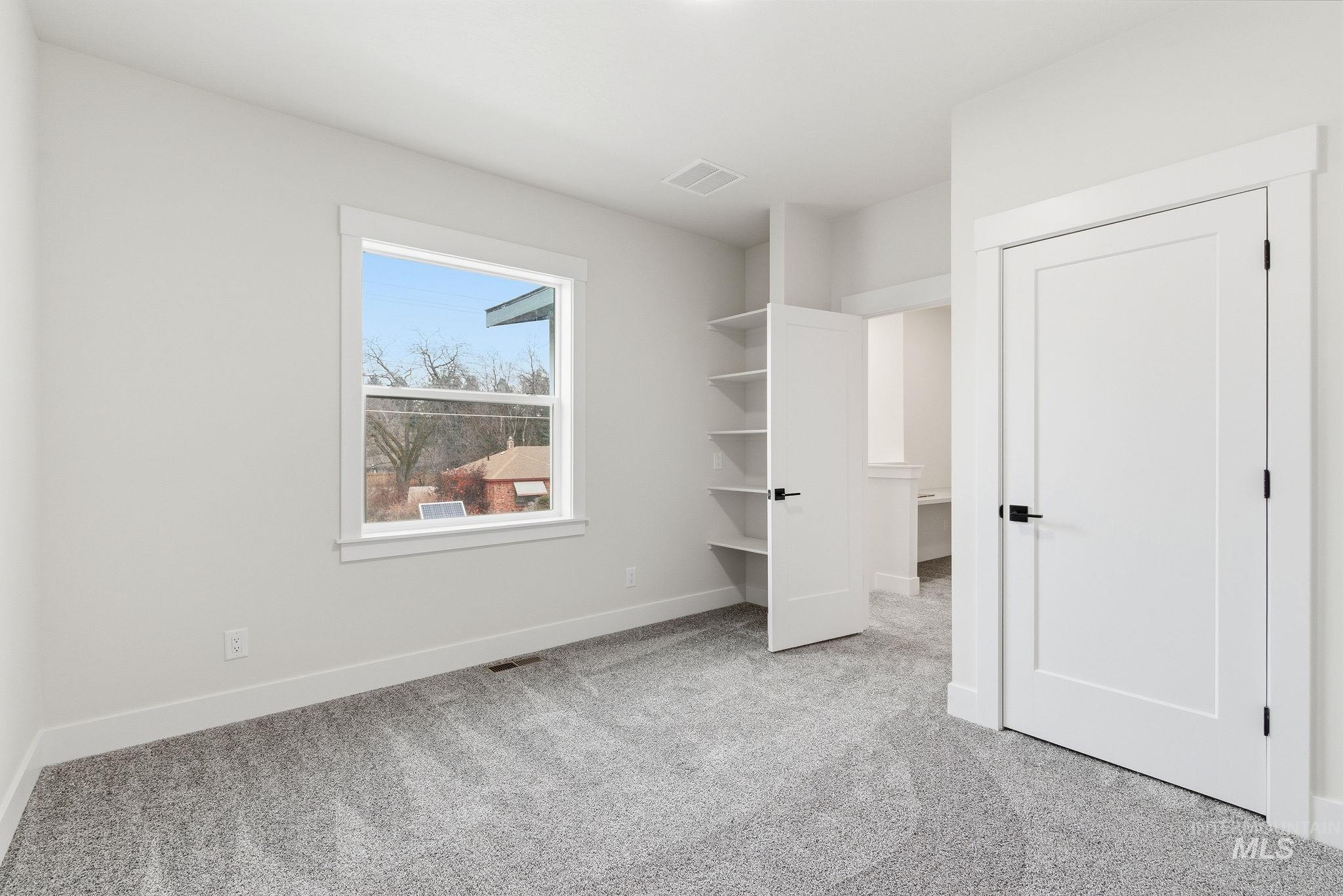 Unfurnished bedroom featuring light carpet and baseboards