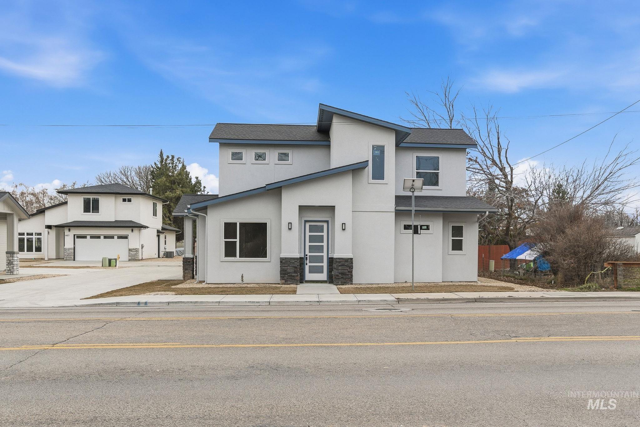 Contemporary house featuring stucco siding, stone siding, and roof with shingles
