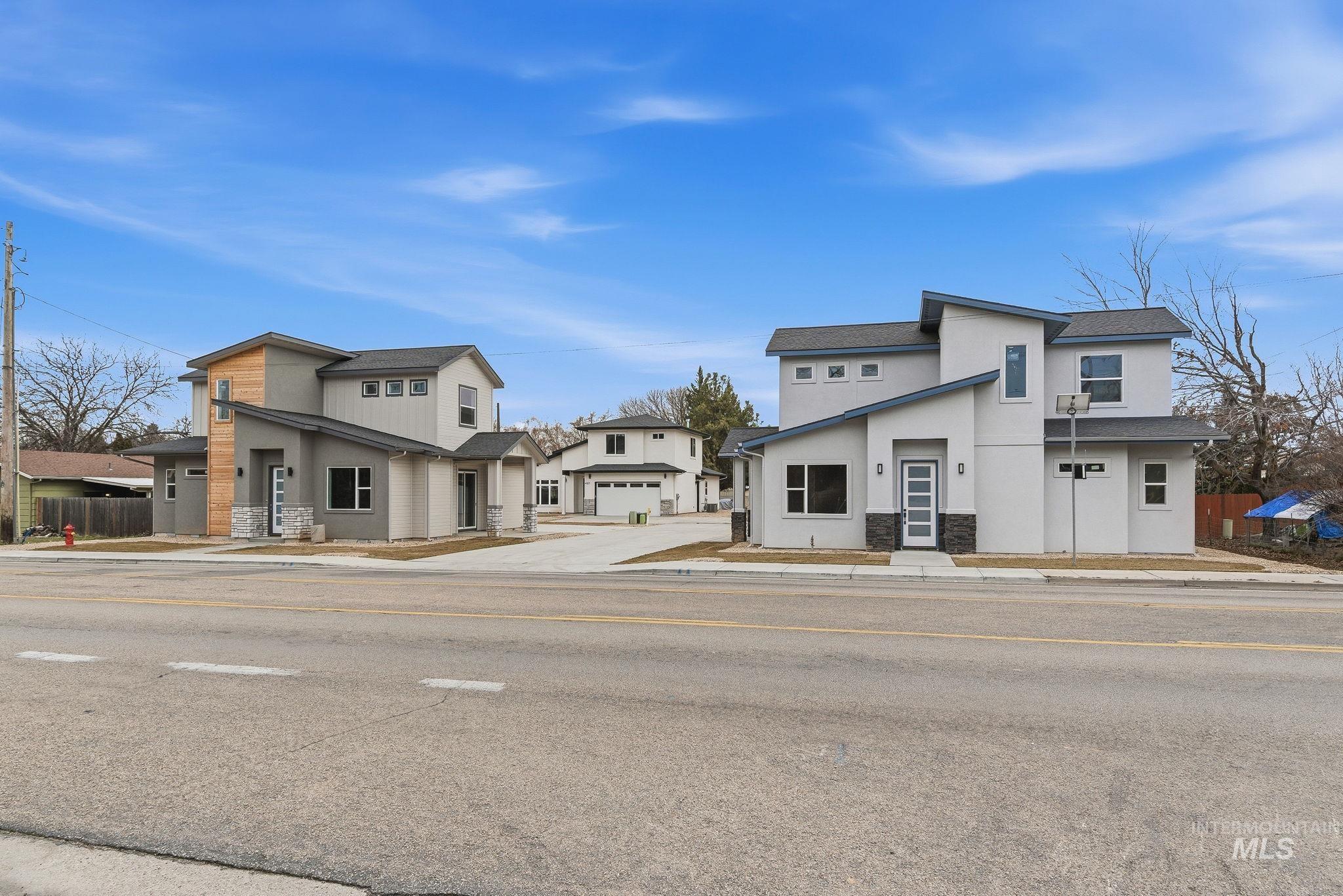 Modern home featuring stucco siding, stone siding, and roof with shingles