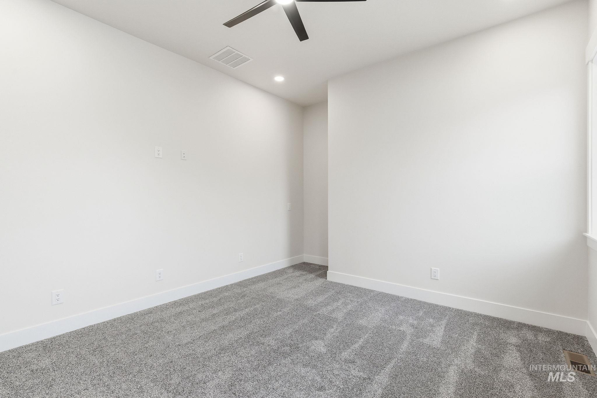 Carpeted spare room with a ceiling fan and recessed lighting