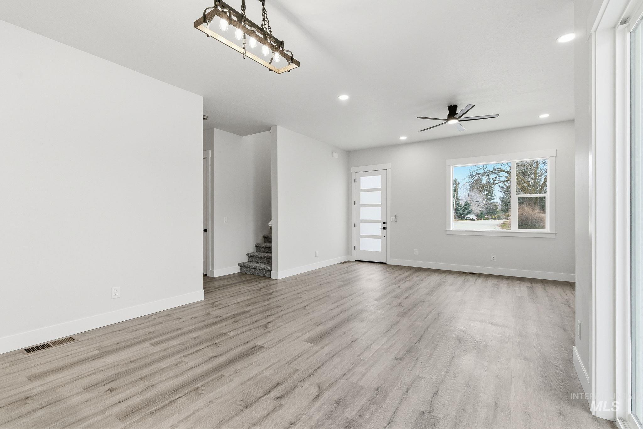 Unfurnished living room with light wood-style floors, a ceiling fan, and recessed lighting