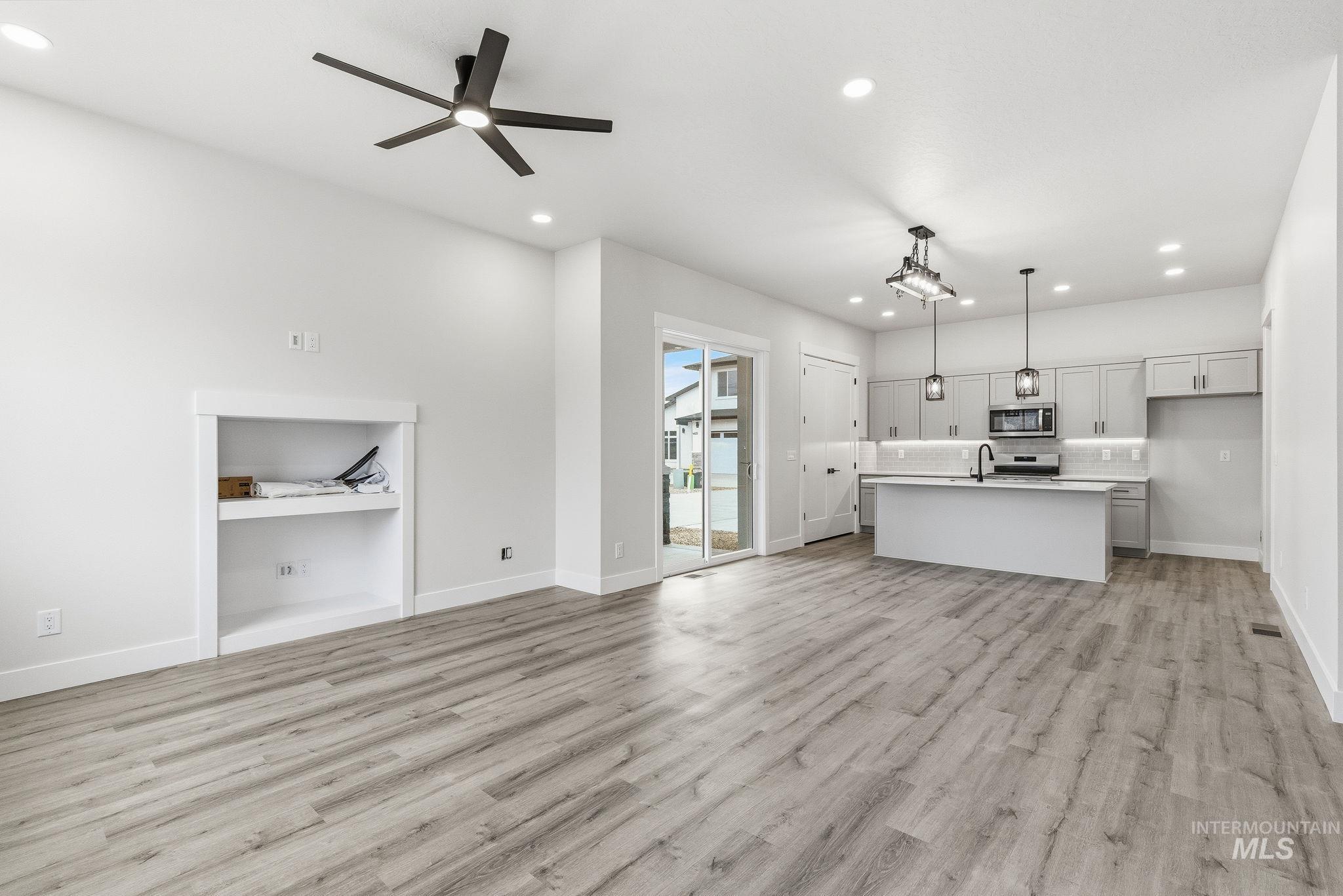 Unfurnished living room featuring recessed lighting, light wood-style flooring, and a ceiling fan