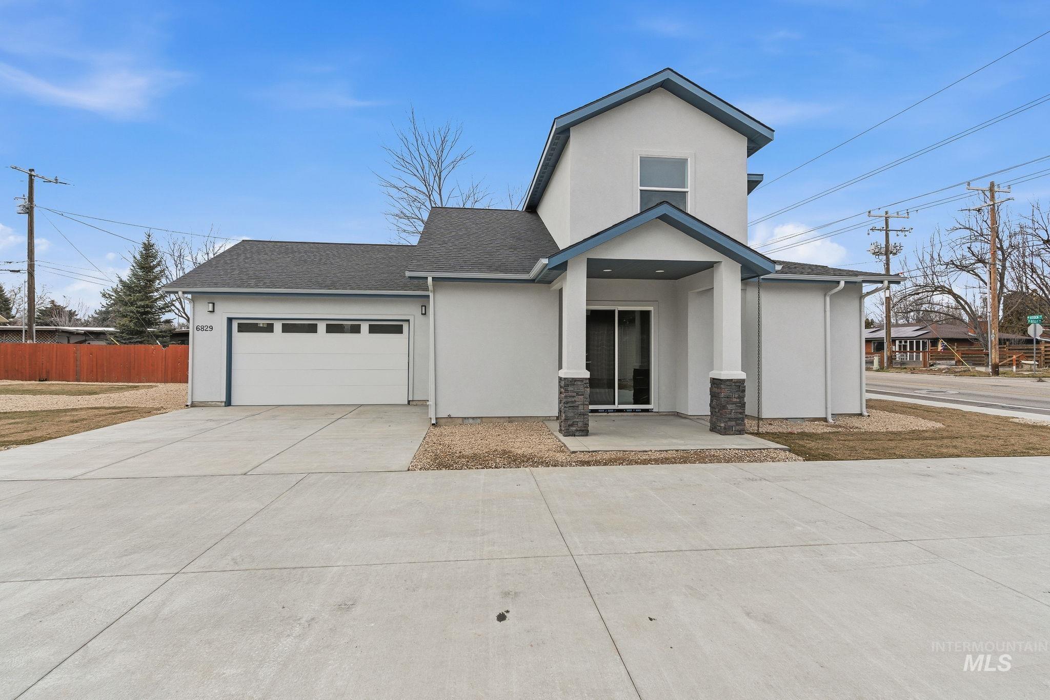 View of front of home featuring stucco siding, concrete driveway, and roof with shingles