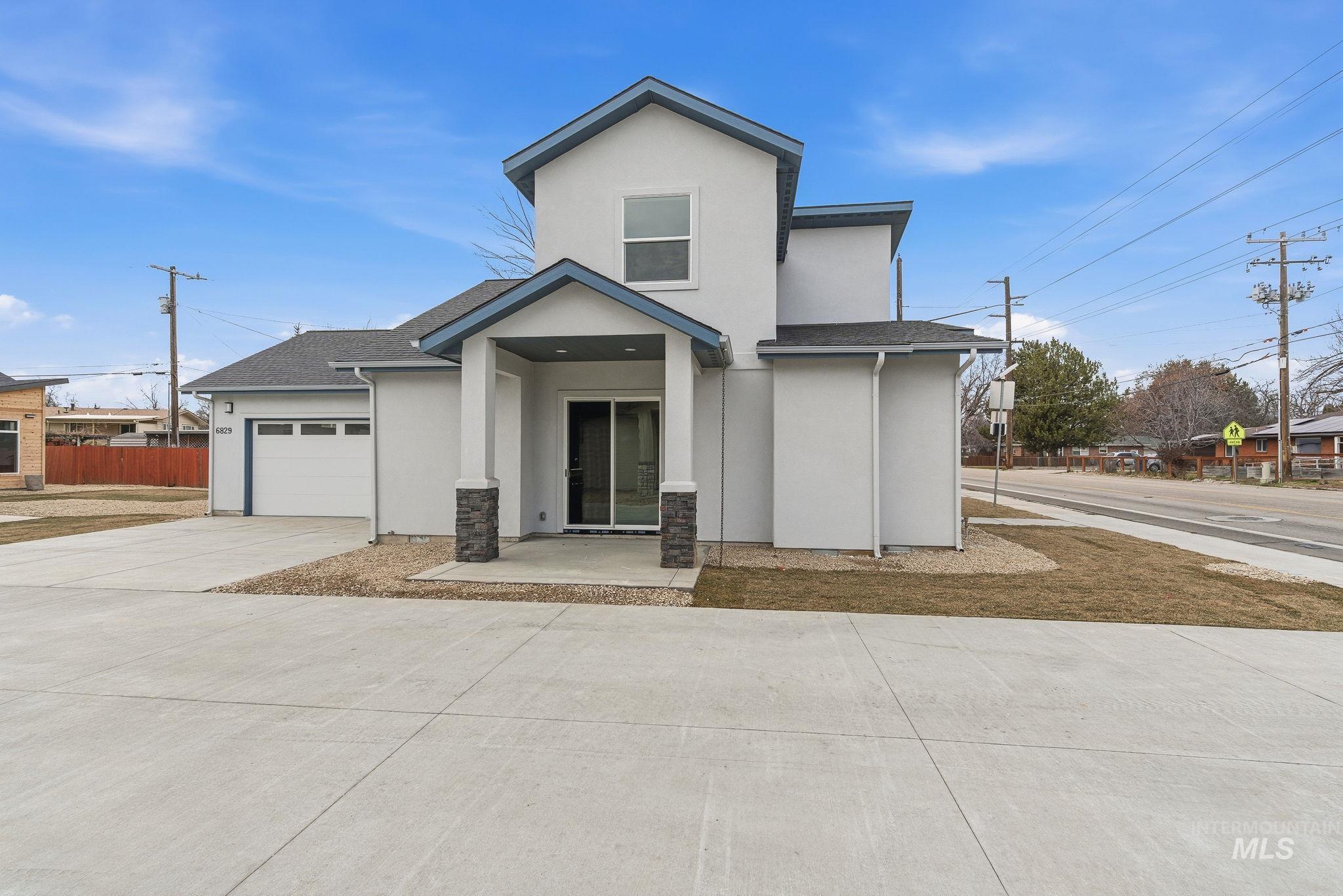 View of front of home with stucco siding, concrete driveway, an attached garage, and a shingled roof