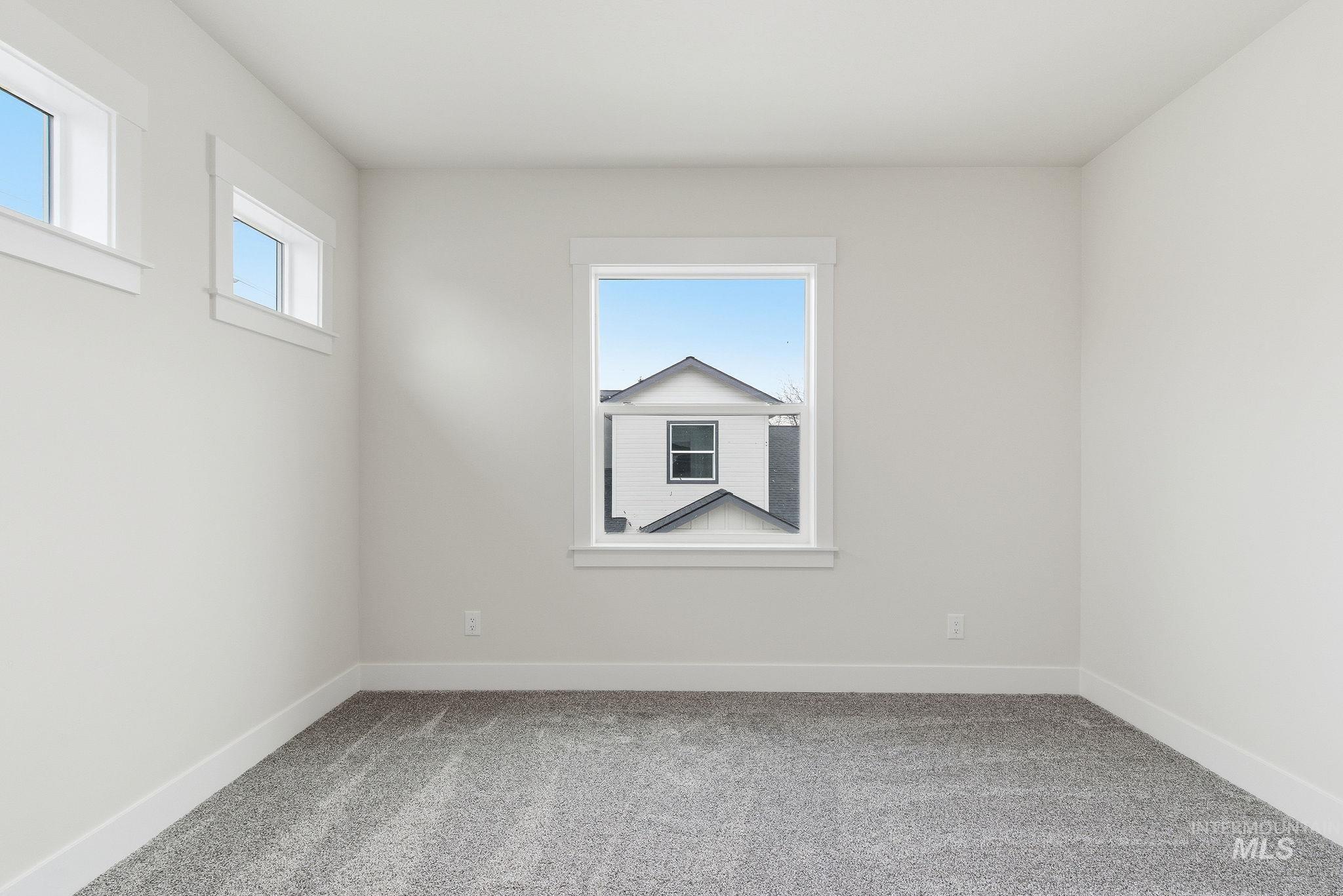Empty room featuring light colored carpet and plenty of natural light