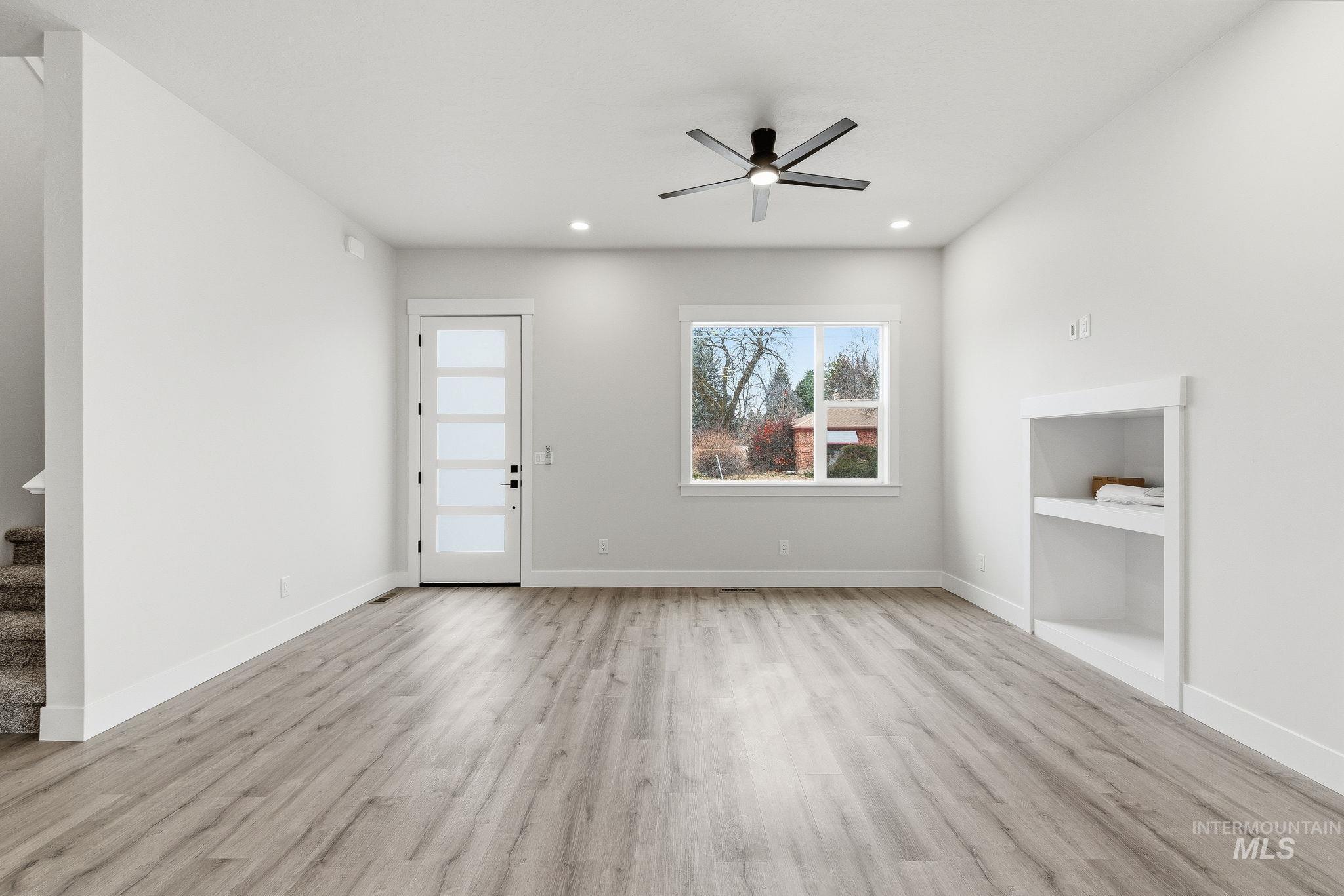 Unfurnished living room featuring light wood-type flooring, ceiling fan, and recessed lighting