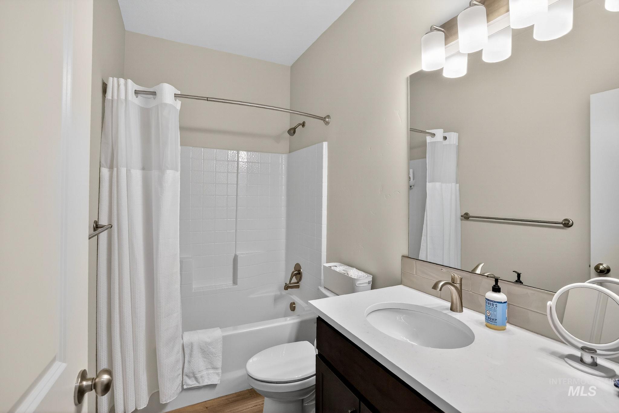 Bathroom featuring a vanity with an undermount sink, a large wall mirror, and a five-light fixture