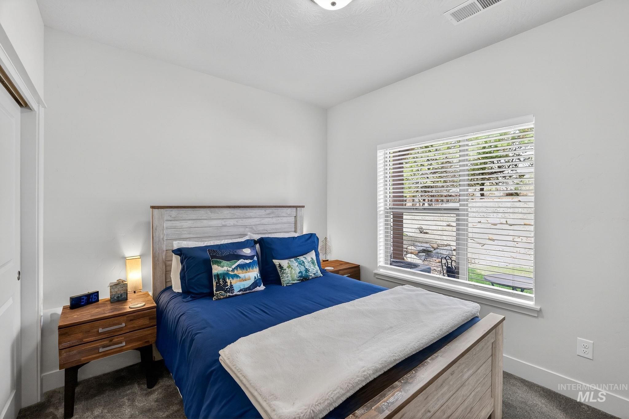 Room featuring a single window with horizontal blinds, providing illumination