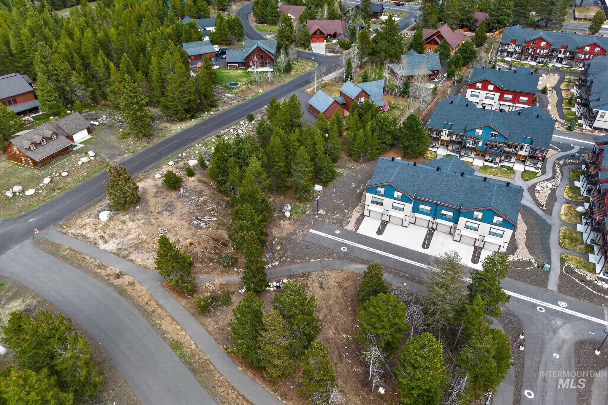 Contemporary townhomes featuring dark gray roofs, light-colored facades, and blue-accented upper levels