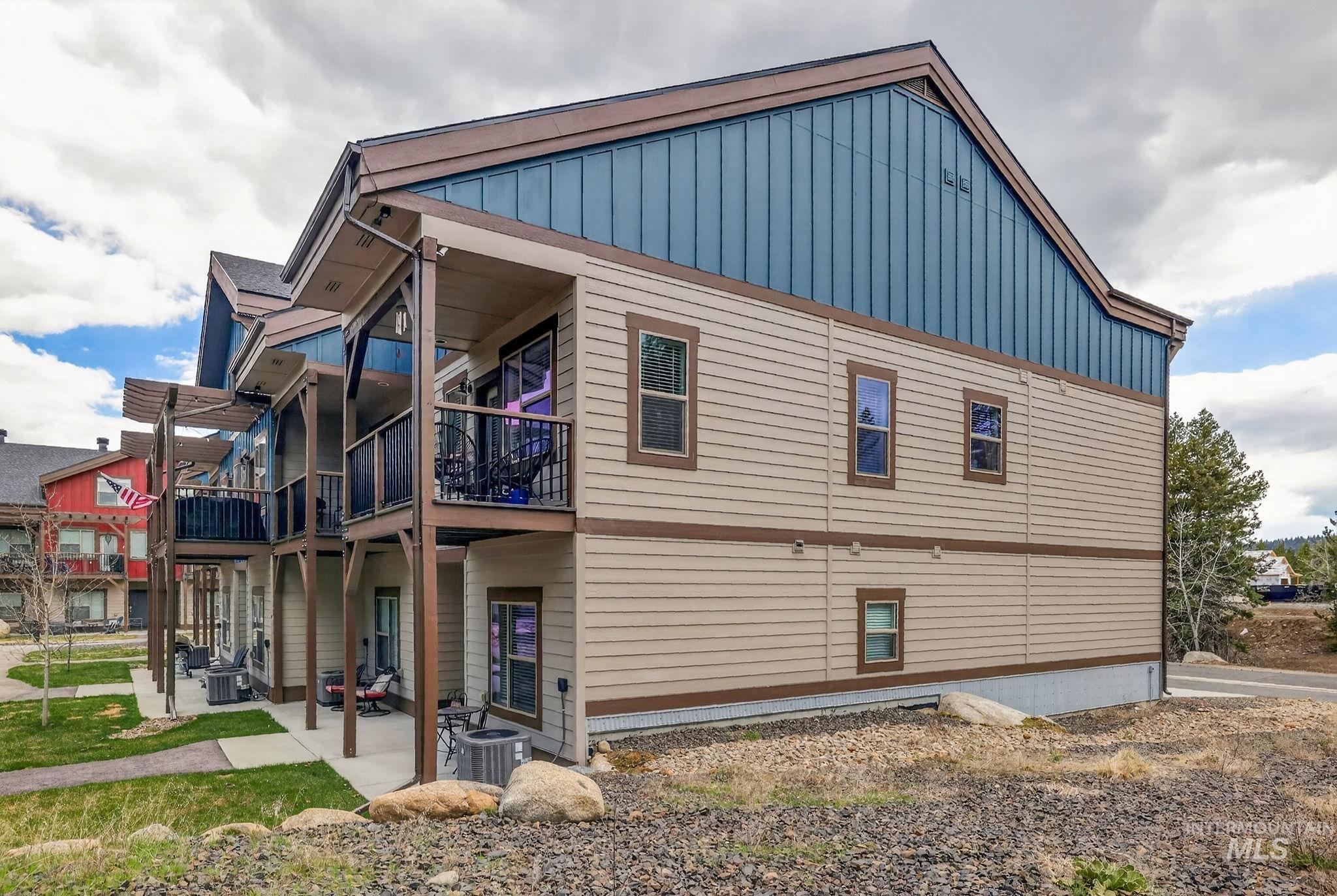 Multi-story residence featuring light-colored horizontal siding with dark trim accents