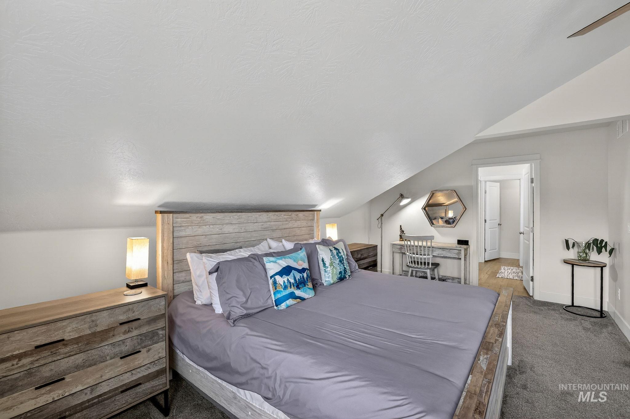 Bedroom featuring sloped ceilings, light gray wall finishes, and gray carpet flooring