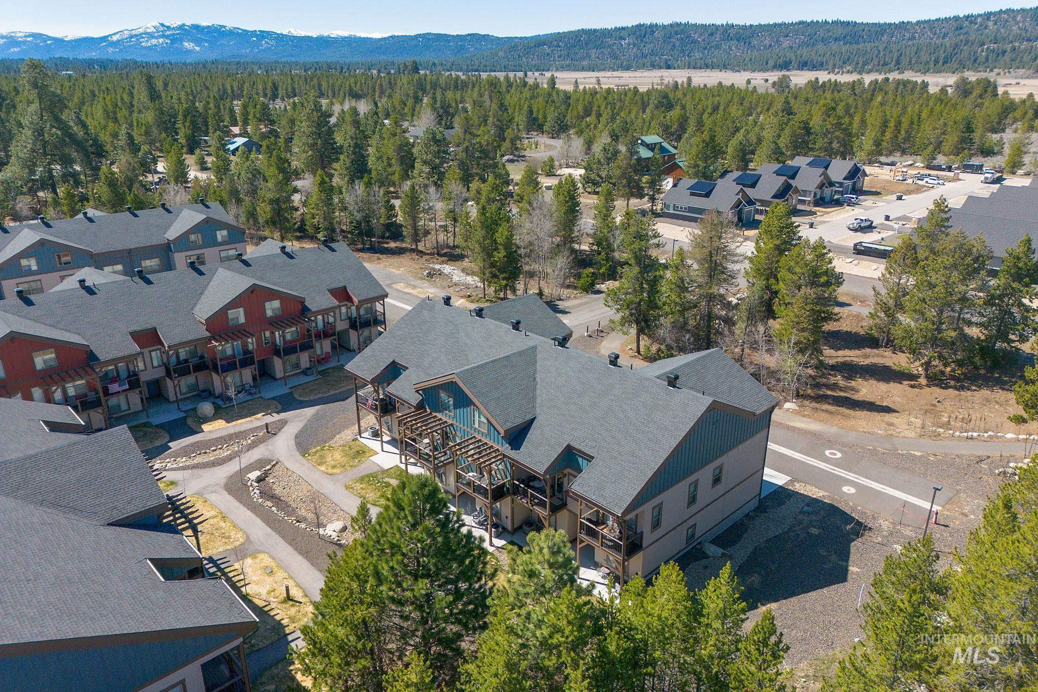 Contemporary multi-story buildings featuring dark shingle roofs, balconies, and exterior siding in various earth tones