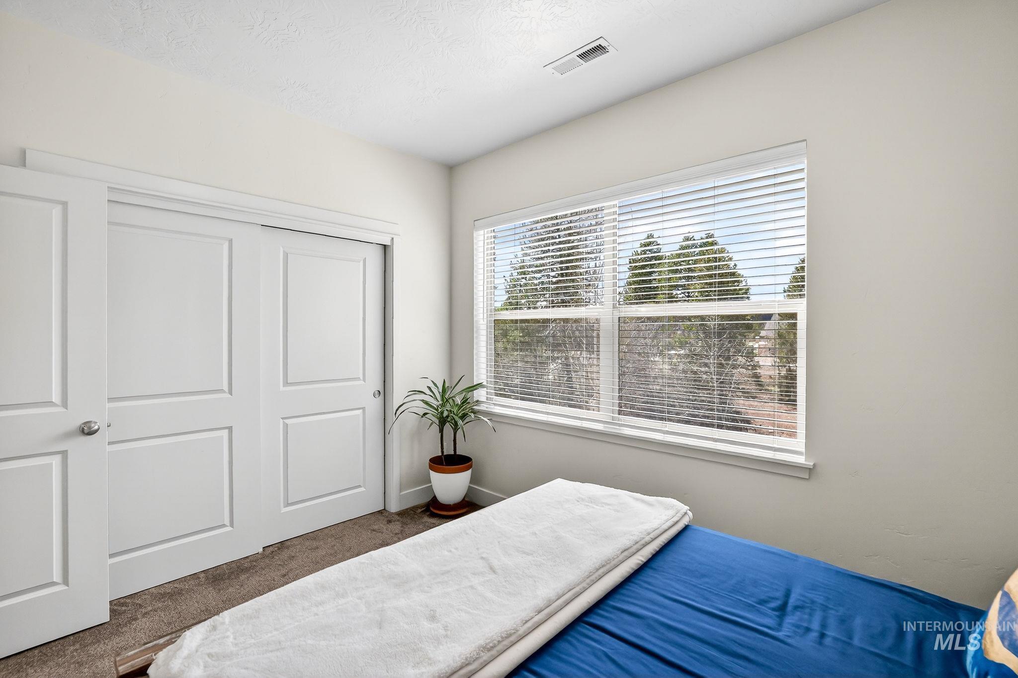 Bright interior space featuring a large window with horizontal blinds, providing natural light