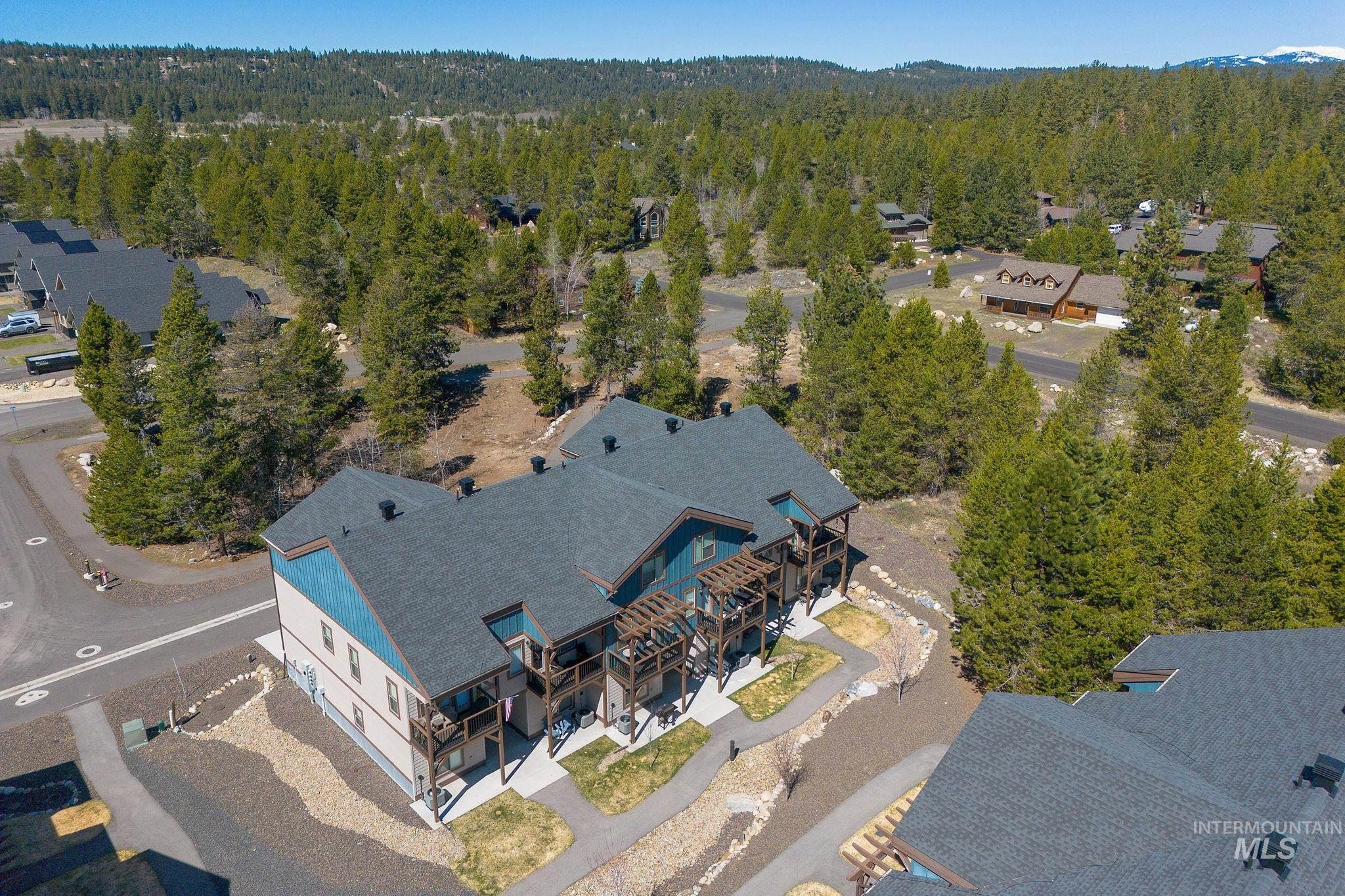 Multi-story building featuring a dark shingle roof and light blue and tan siding