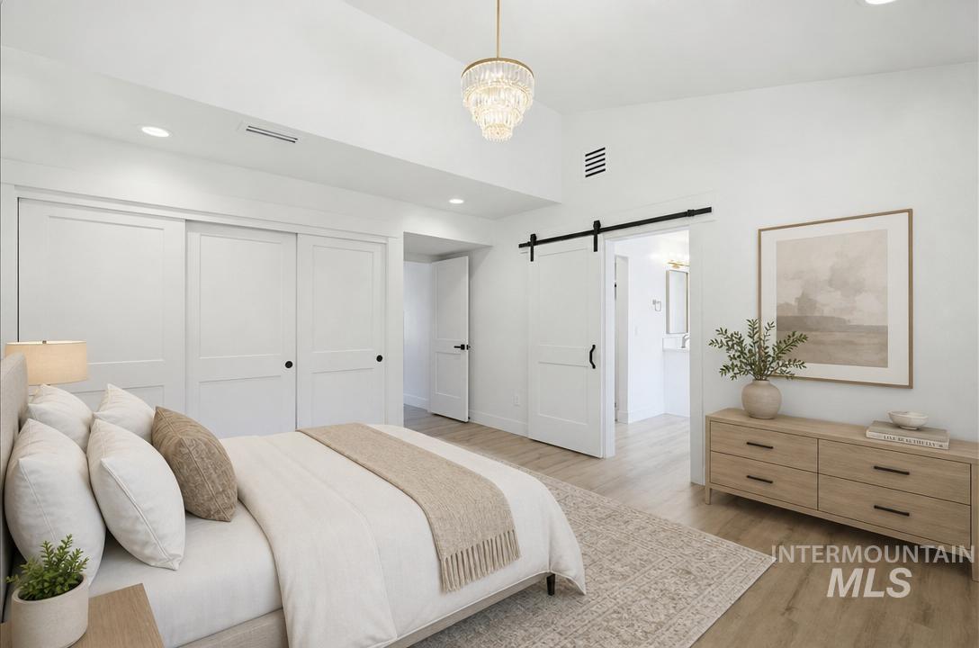 Bright interior featuring wood-finish flooring and a contemporary chandelier