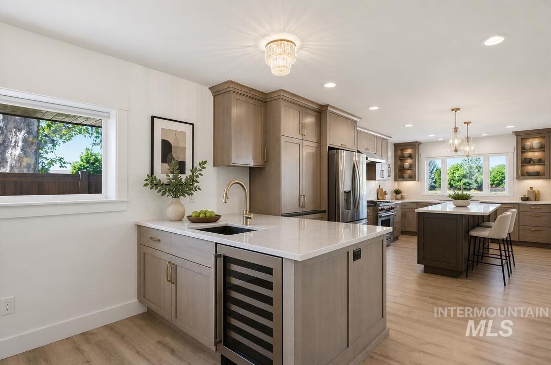 Gourmet kitchen with light wood-finish flooring, two central islands with quartz countertops, integrated wine refrigeration, and stainless steel appliances