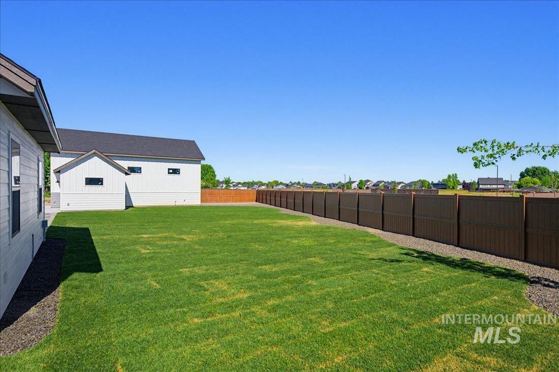 Expansive green lawn with a full perimeter fence