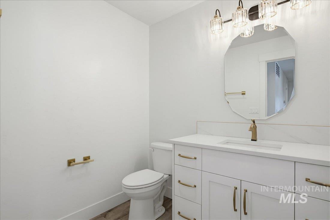 Bathroom featuring a white vanity with gold-tone hardware, an integrated rectangular sink, and a white countertop with a matching backsplash