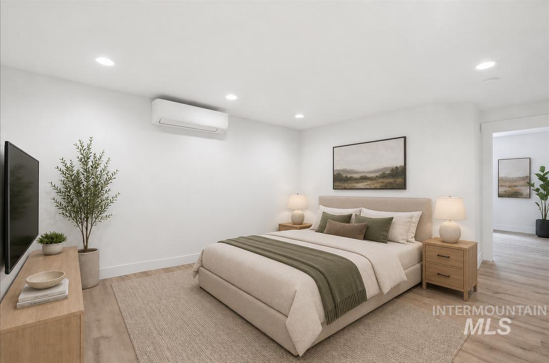 Room featuring recessed lighting, wood-finish flooring, and a wall-mounted mini-split HVAC unit