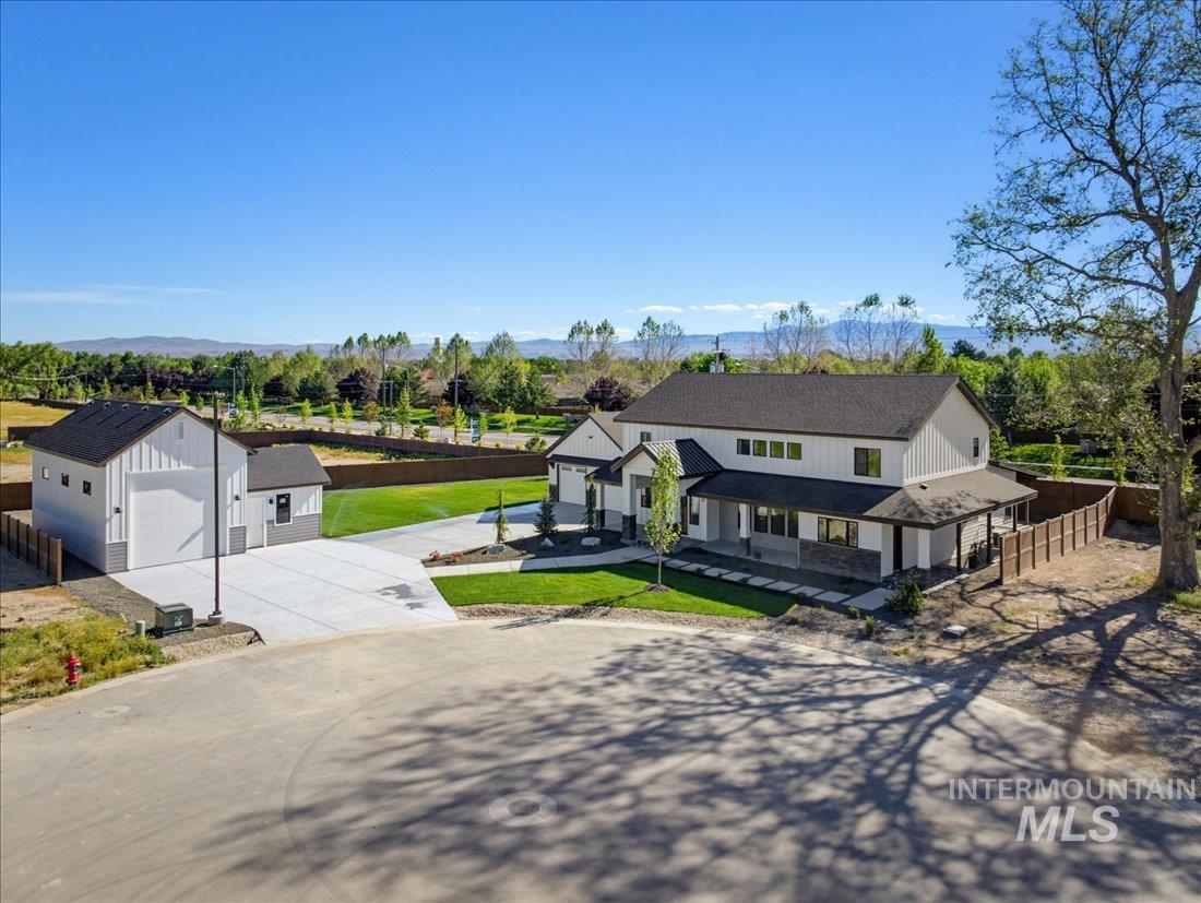 Modern farmhouse-style residence featuring a two-story design, dark-pitched roof, and a covered front porch