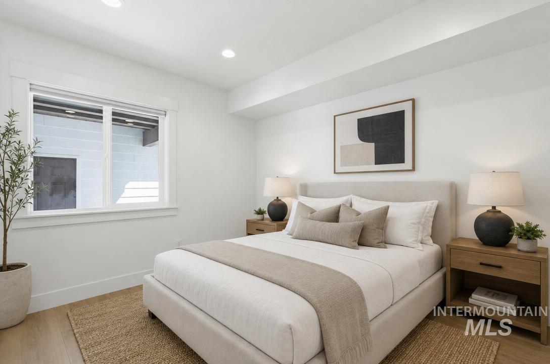 Bright bedroom featuring recessed lighting and wood-finish flooring