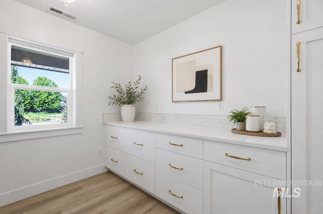 Built-in white cabinetry with gold-finish hardware, offering extensive storage