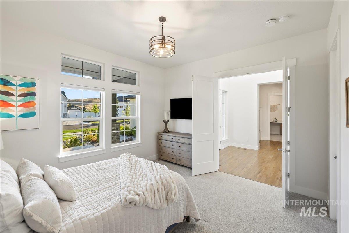 Bedroom featuring light carpet and baseboards