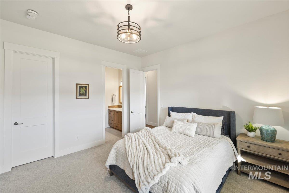 Bedroom featuring light colored carpet and ensuite bathroom